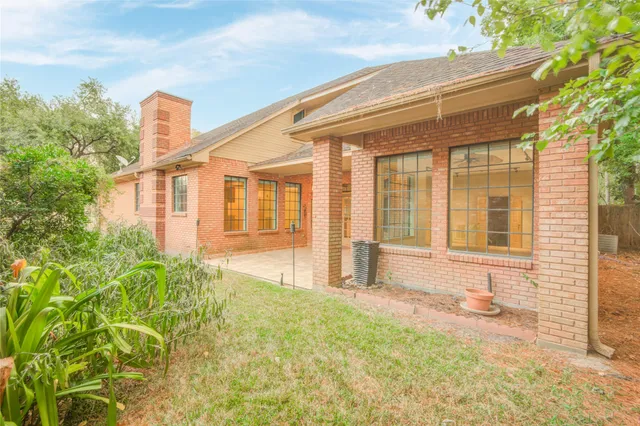 a view of house with backyard and glass windows