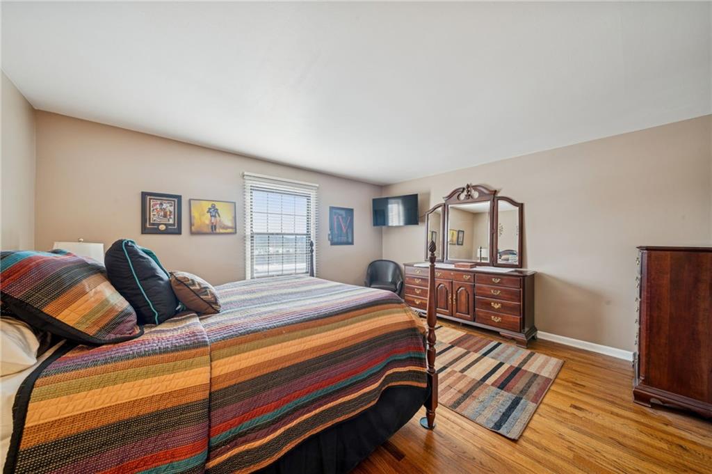 117 Community Court Pittsburgh, PA 15205 - Photo 20 of 34 a bedroom with a bed next to a large window with wooden floor