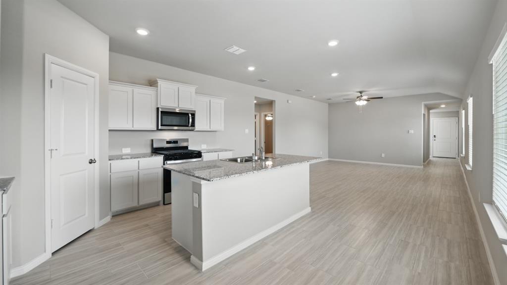 172 Mojave Road Boyd, TX 76023 - Photo 38 of 40 a kitchen with a sink a microwave a refrigerator and cabinets