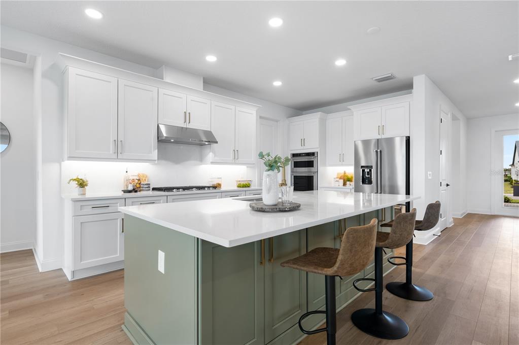 5856 Freestone Circle Apollo Beach, FL 33572 - Photo 11 of 33 a kitchen with stainless steel appliances granite countertop a table chairs sink refrigerator and cabinets