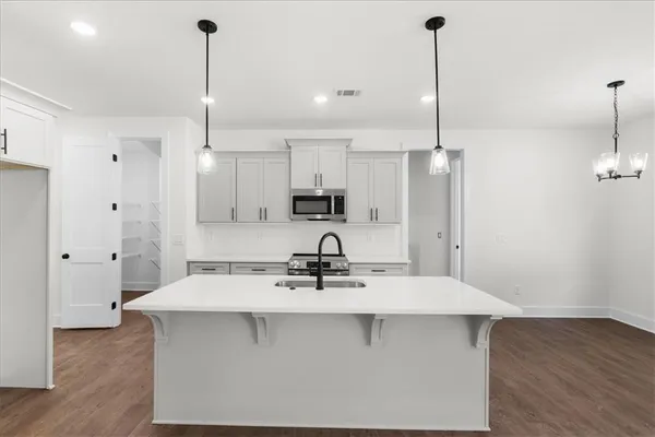 a kitchen with kitchen island a sink stainless steel appliances and cabinets