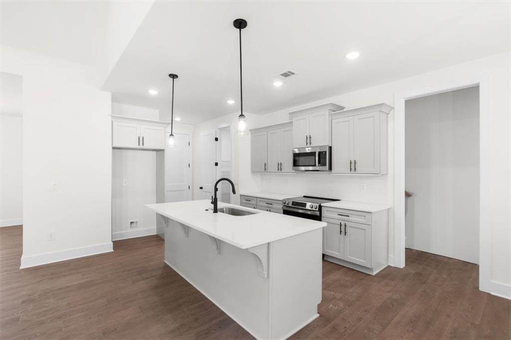 7 Everwood Court Rome, GA 30161 - Photo 18 of 55 a kitchen with stainless steel appliances granite countertop a sink a stove a refrigerator and white cabinets with wooden floor