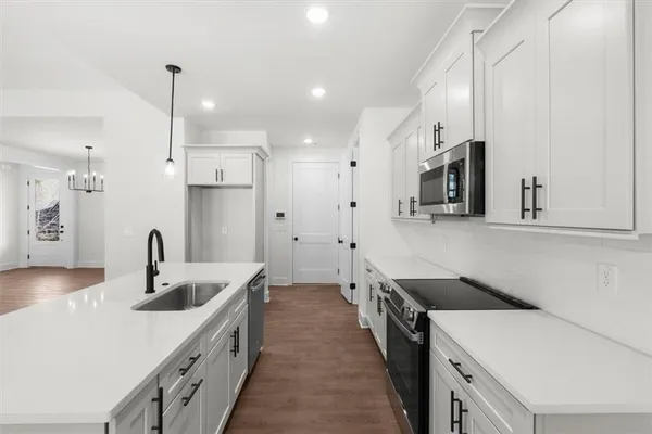 a kitchen with stainless steel appliances granite countertop a sink a window and a fireplace