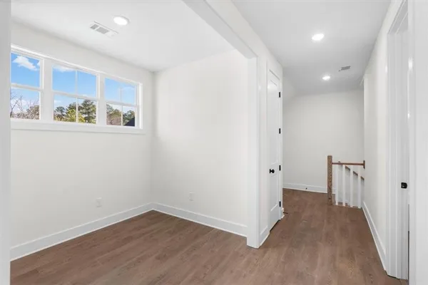 an empty room with windows and ceiling fan