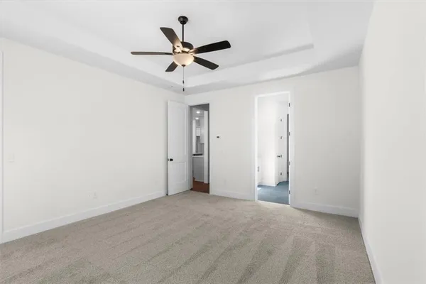 en empty room with windows and ceiling fan