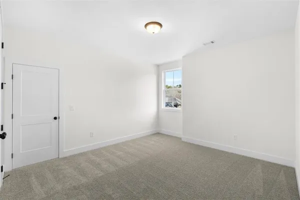 a white toilet sitting next to a white wall