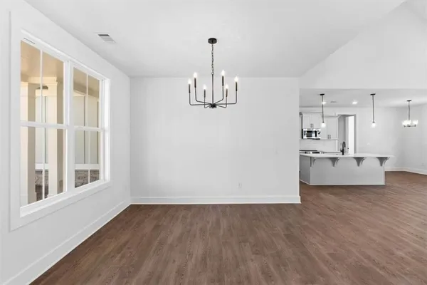 a view of a kitchen with wooden floor and windows