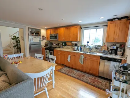 a kitchen with stainless steel appliances granite countertop sink stove refrigerator and dining table