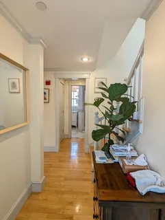 a living room with furniture a wooden floor and next to a window