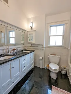 a bathroom with a toilet sink and mirror