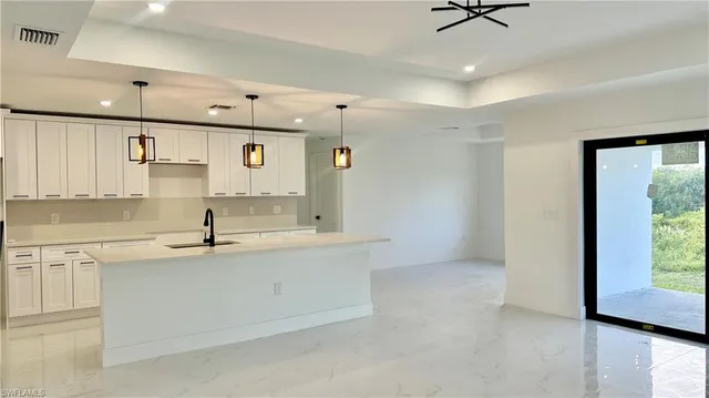 a kitchen with a sink appliances and cabinets