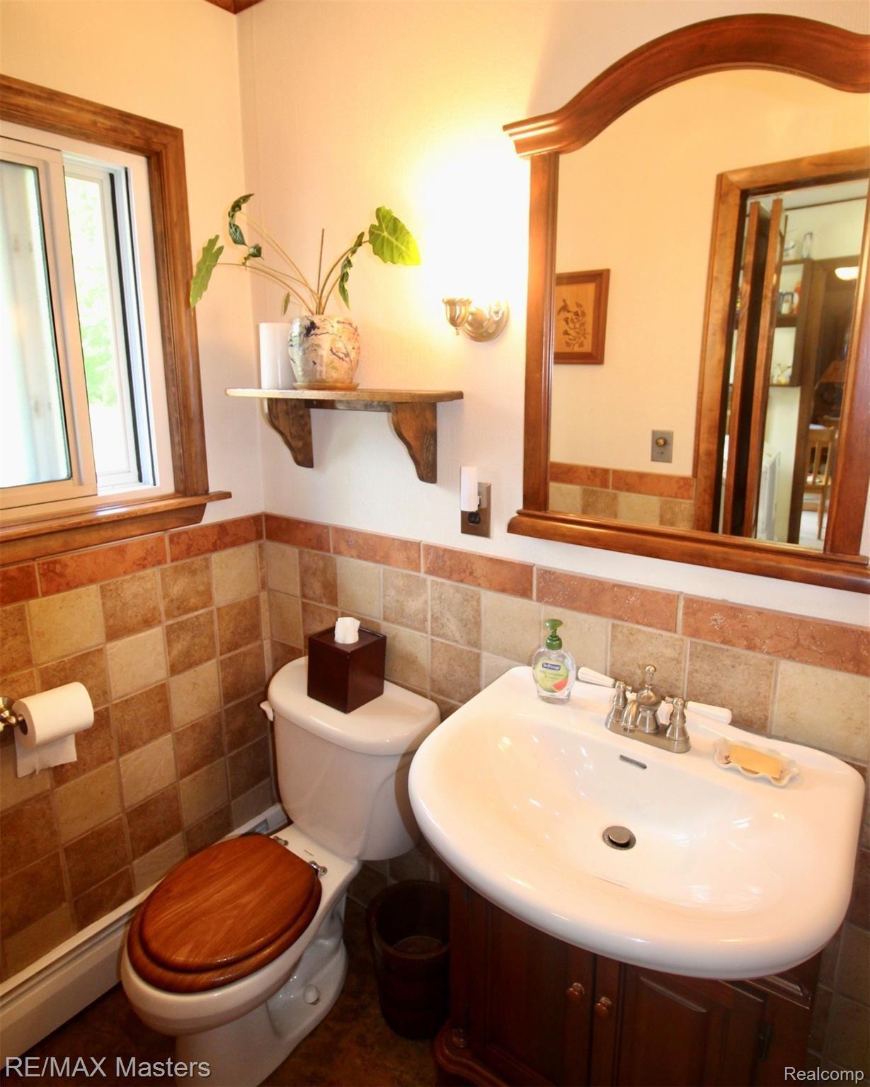 25777 Inkster Road Flat Rock, MI 48134 - Photo 21 of 52 This tiled half bath with unique wall sink and storage underneath is right off the garage, and utility room, perfect!