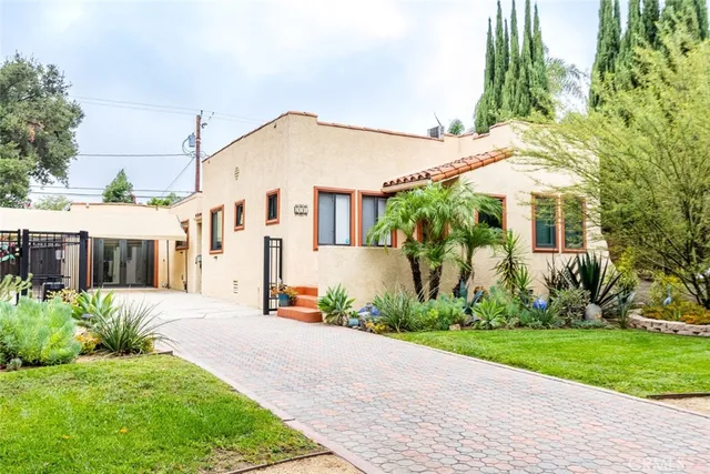 a front view of a house with a yard and potted plants