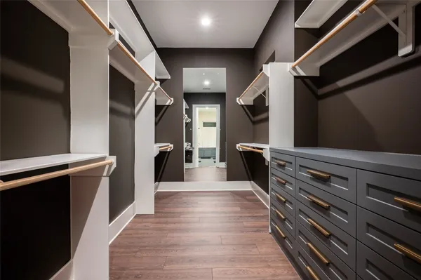 a hallway with wooden floors and couches