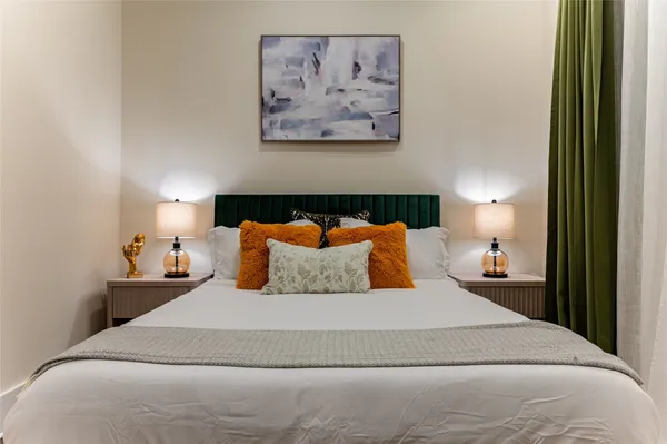 a bedroom with a bed and a painting on the wall