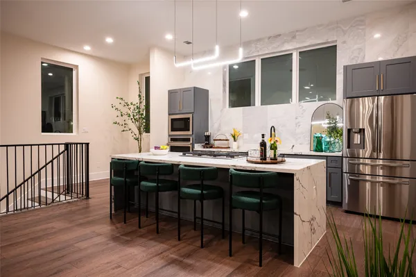 a kitchen with kitchen island granite countertop wooden cabinets and a refrigerator