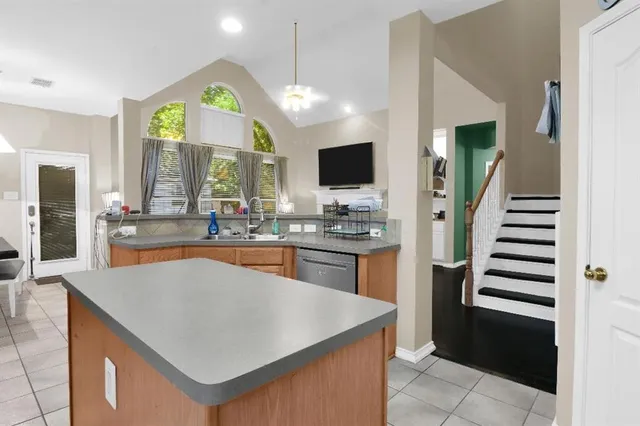 a kitchen with stainless steel appliances kitchen island granite countertop a refrigerator a stove and a sink