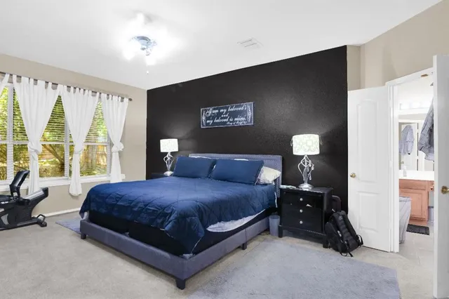 a spacious bedroom with a bed and a large window