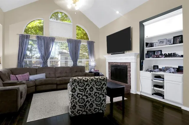 a living room with furniture a flat screen tv and a fireplace