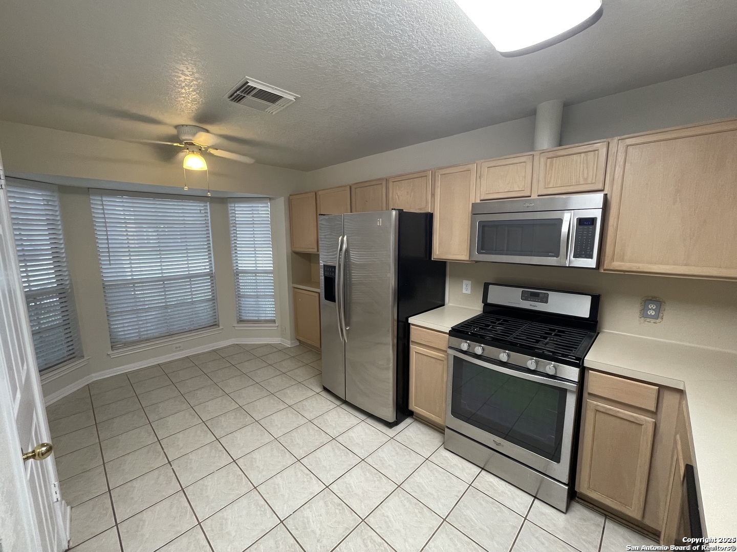 7522 Sutters Mine Converse, TX 78109 - Photo 11 of 18 a kitchen with granite countertop a refrigerator and a stove top oven