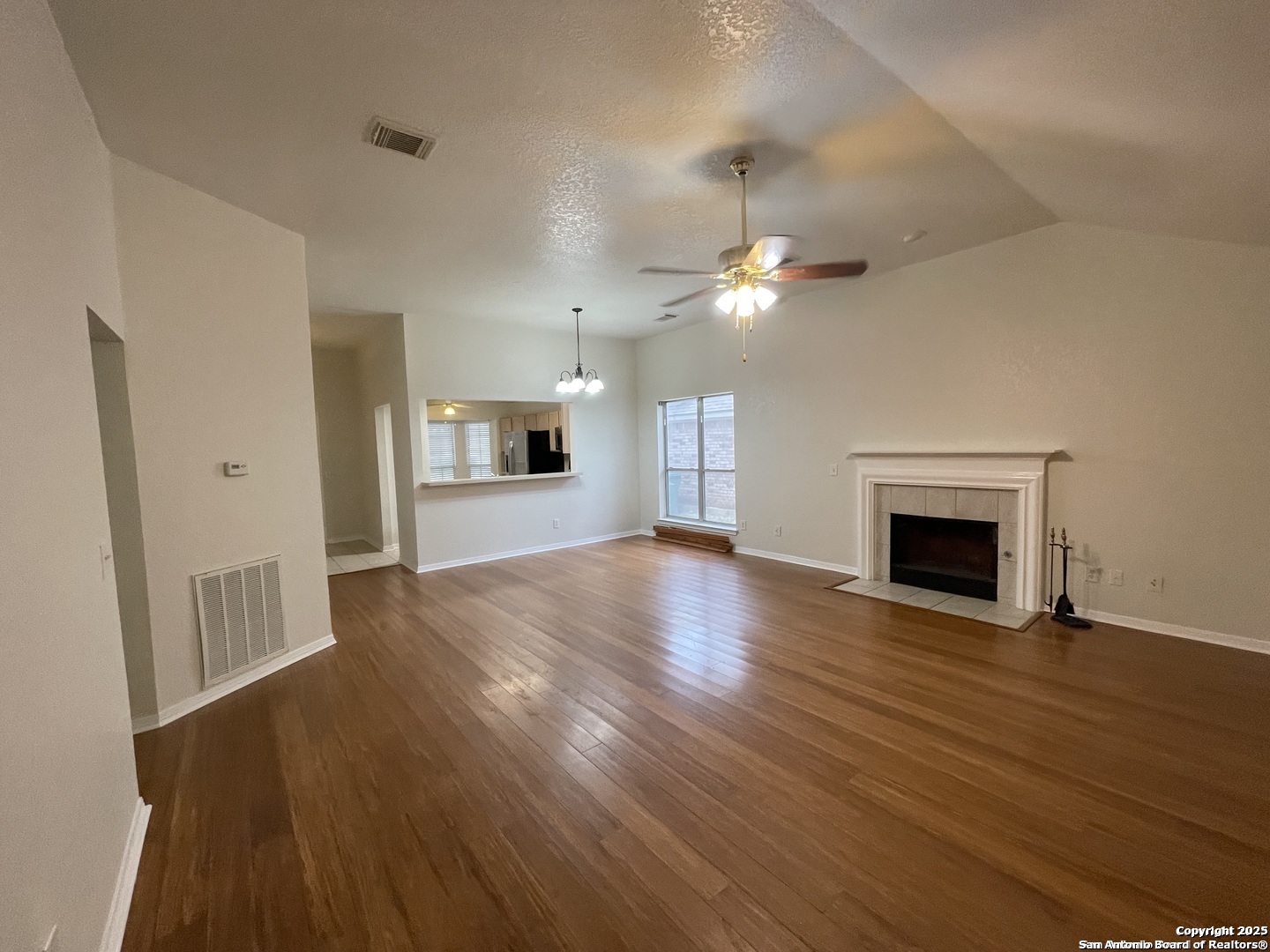 7522 Sutters Mine Converse, TX 78109 - Photo 6 of 18 a view of a livingroom with a fireplace a ceiling fan and wooden floor