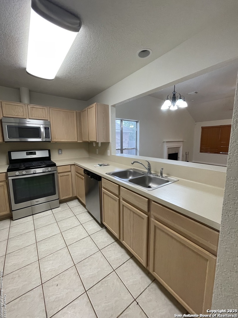 7522 Sutters Mine Converse, TX 78109 - Photo 10 of 18 a kitchen with stainless steel appliances a sink a stove a microwave and a refrigerator