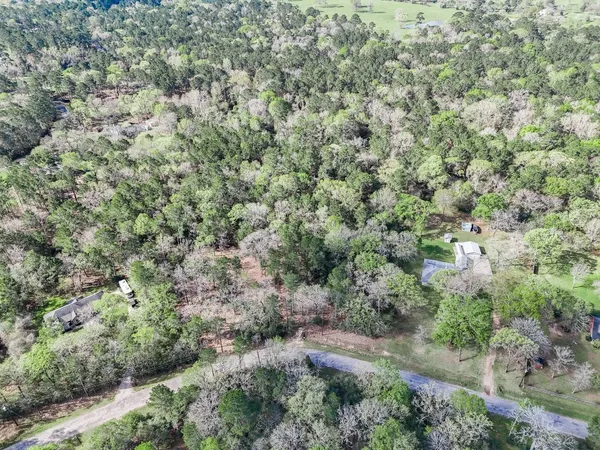 an aerial view of residential house with space and trees all around