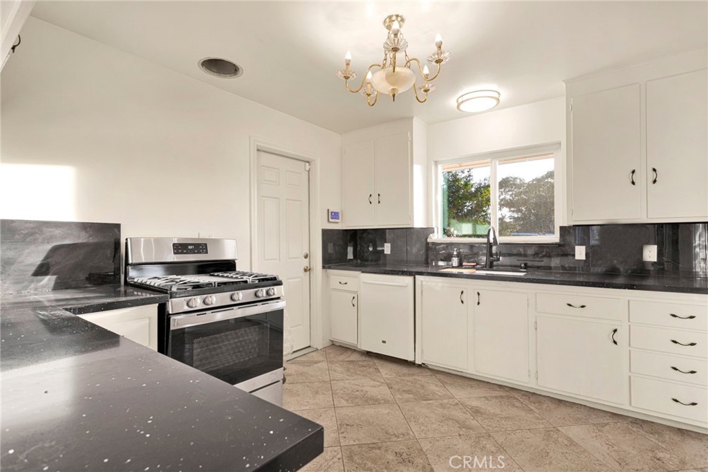 15177 Mendota Road North Apple Valley, CA 92307 - Photo 9 of 50 a kitchen with granite countertop stainless steel appliances a stove a sink a counter space and cabinets