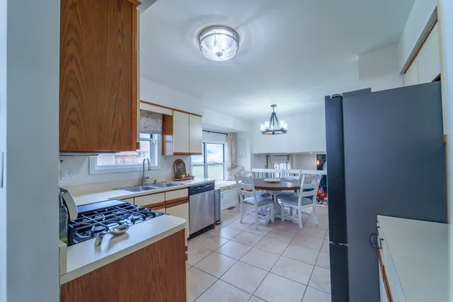a kitchen with stainless steel appliances a table and chairs in it