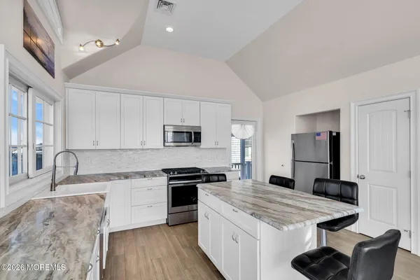 a kitchen with stainless steel appliances granite countertop a sink stove and refrigerator