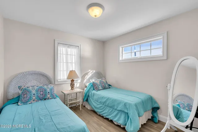 a bedroom with two beds and a lamp