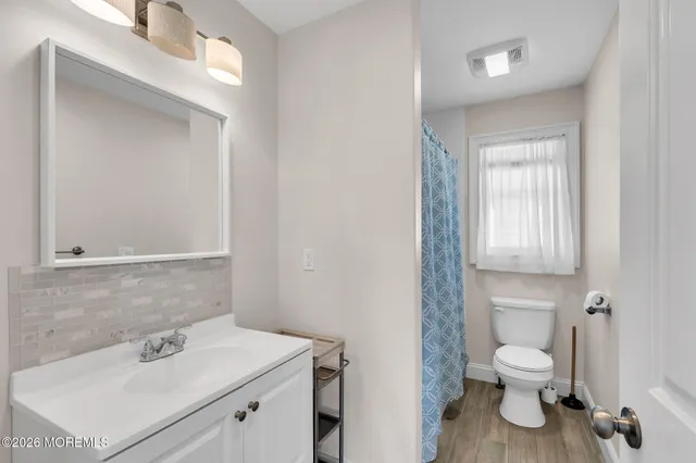a bathroom with a sink toilet and a mirror