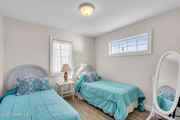 a bedroom with two beds and a lamp