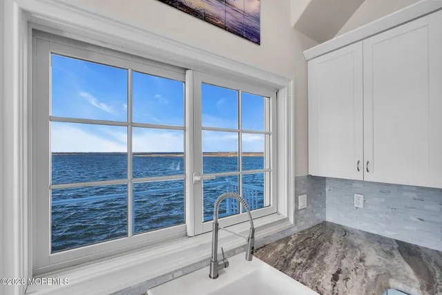 a view of a livingroom with the kitchen and a window
