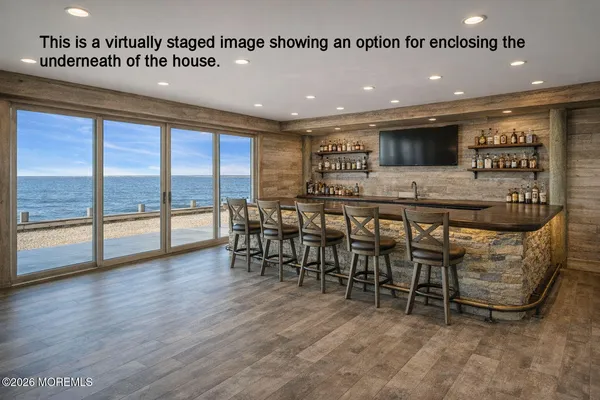 a dining hall with stainless steel appliances granite countertop a stove and a view of living room
