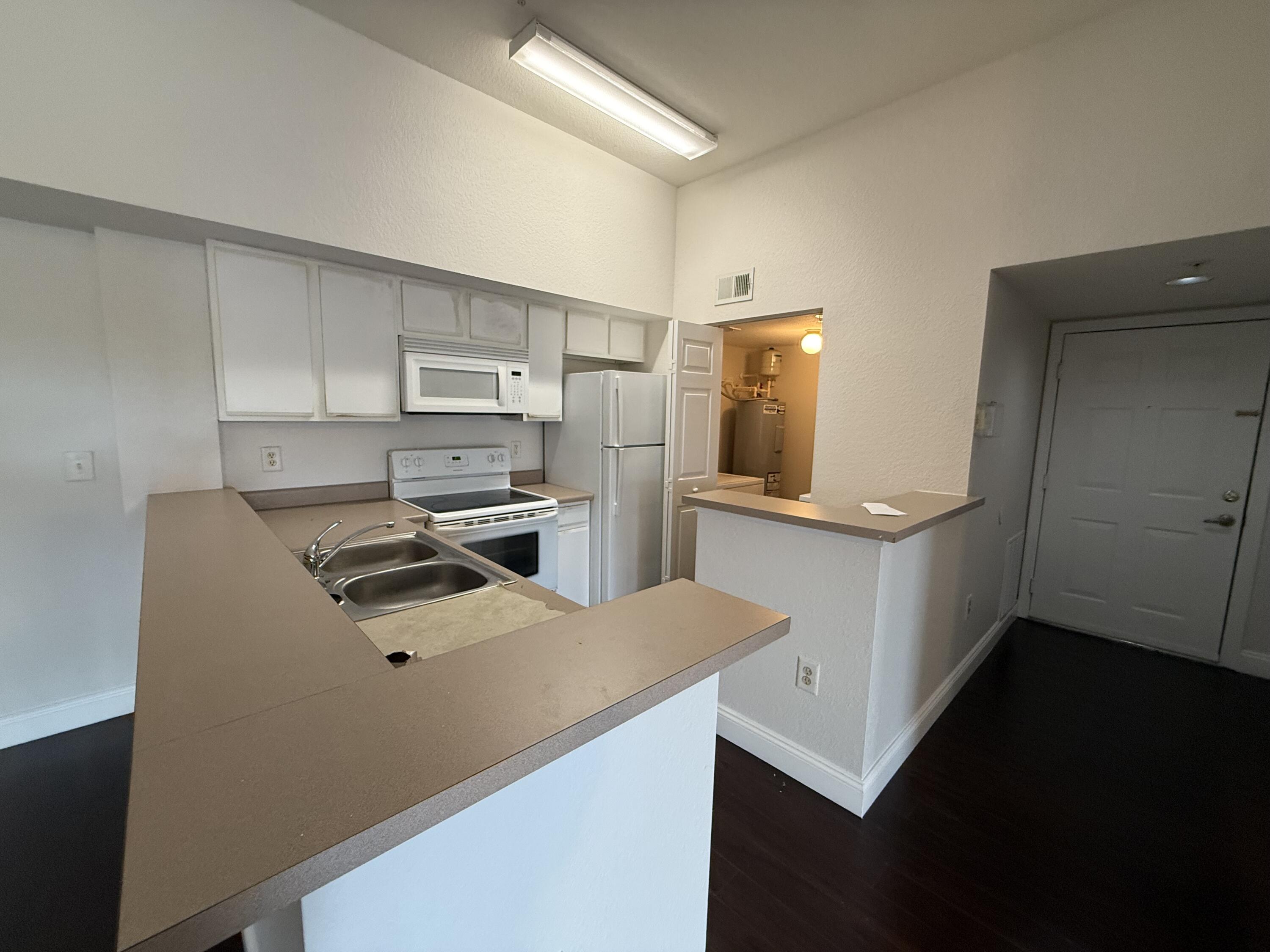 171 Southwest Palm Drive, Unit 303 Port St. Lucie, FL 34986 - Photo 1 of 9 a kitchen with a refrigerator sink and stove