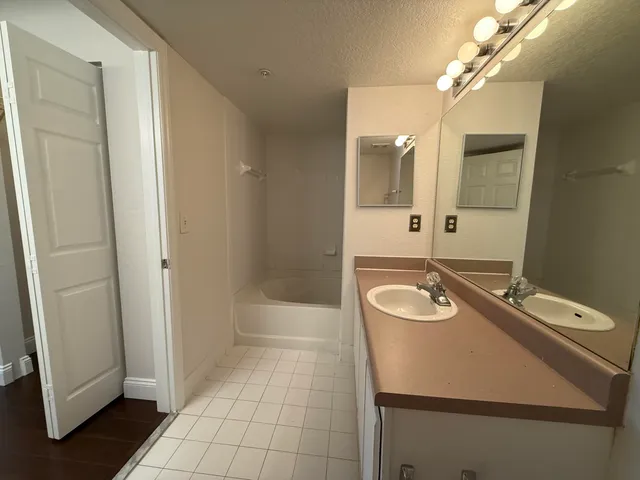 a bathroom with a sink a toilet a mirror and shower