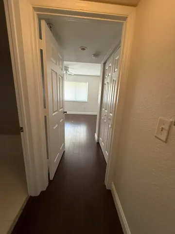 a view of a hallway with wooden floor and staircase