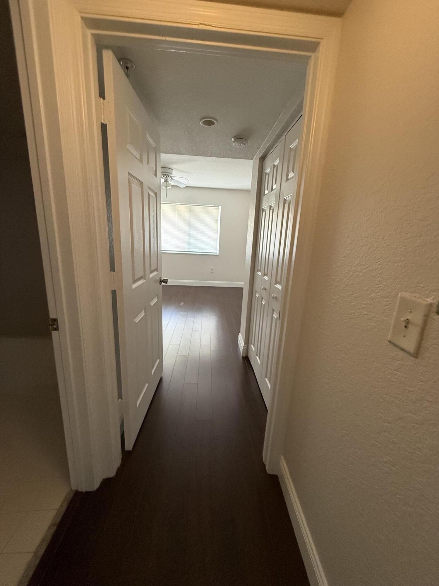 171 Southwest Palm Drive, Unit 303 Port St. Lucie, FL 34986 - Photo 9 of 9 a view of a hallway with wooden floor and staircase