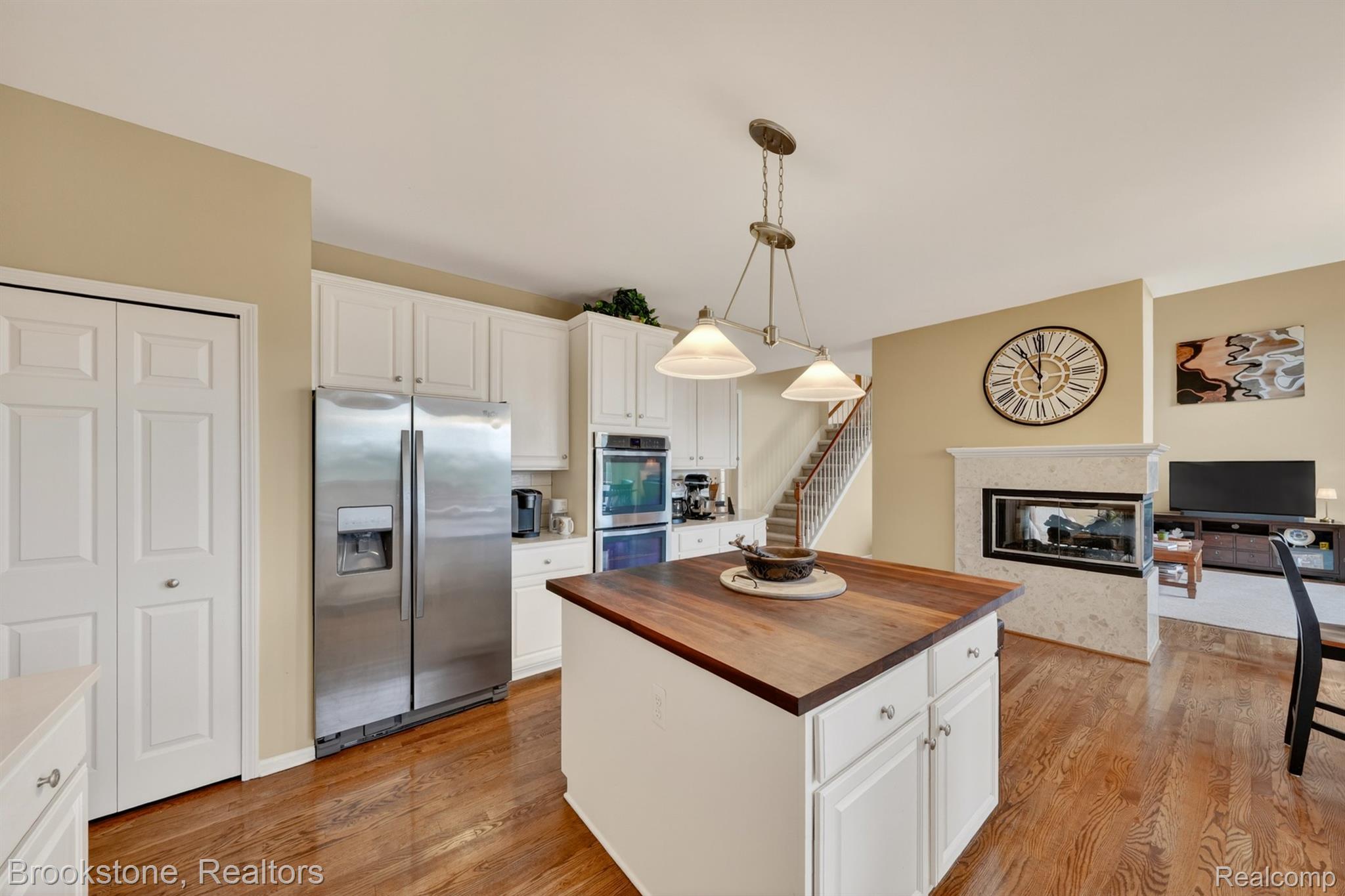 4054 Calumet Drive Rochester, MI 48306 - Photo 12 of 44 Kitchen featuring butcher block countertops, stainless steel appliances, a center island, white cabinetry, and hanging light fixtures