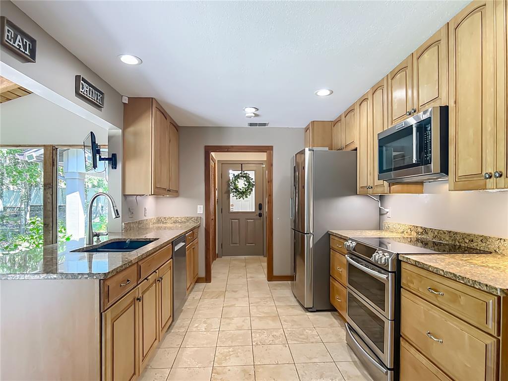 4661 Southwest 7th Avenue Road Ocala, FL 34471 - Photo 22 of 94 a kitchen with stainless steel appliances granite countertop a sink stove refrigerator and cabinets