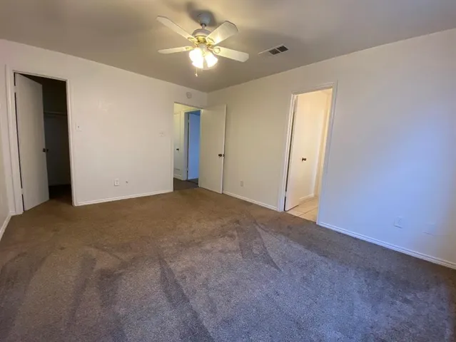 a view of a big room with chandelier fan and windows