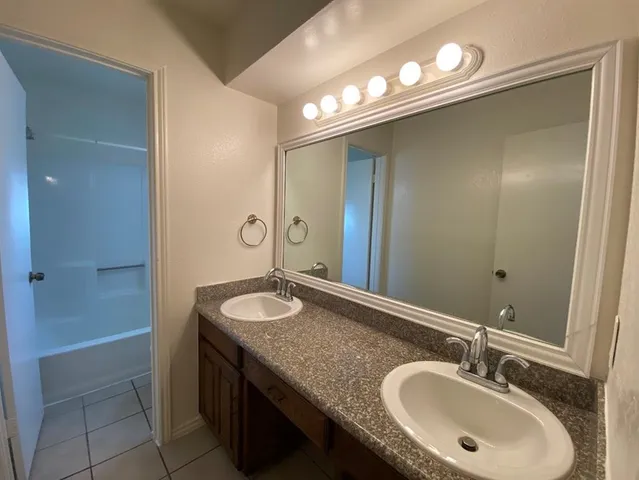 a bathroom with a granite countertop sink and a mirror