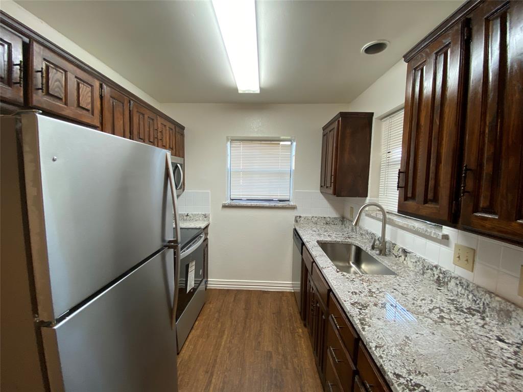 2110 Stone Moss Lane Grapevine, TX 76051 - Photo 5 of 14 a kitchen with granite countertop stainless steel appliances a refrigerator and a sink