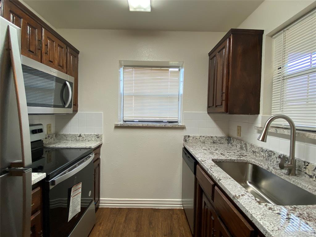 2110 Stone Moss Lane Grapevine, TX 76051 - Photo 6 of 14 a kitchen with stainless steel appliances granite countertop a sink stove and refrigerator