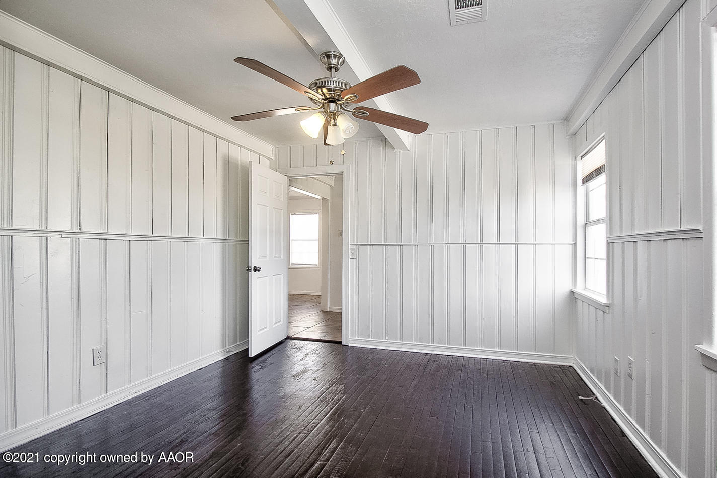 4431 Bowie Street Amarillo, TX 79110 - Photo 7 of 13 an empty room with wooden floor fan and windows