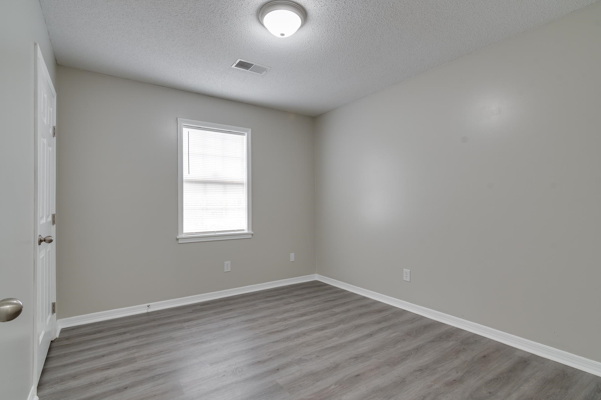 282 Volz Road Ripley, TN 38063 - Photo 13 of 25 wooden floor in an empty room with a window