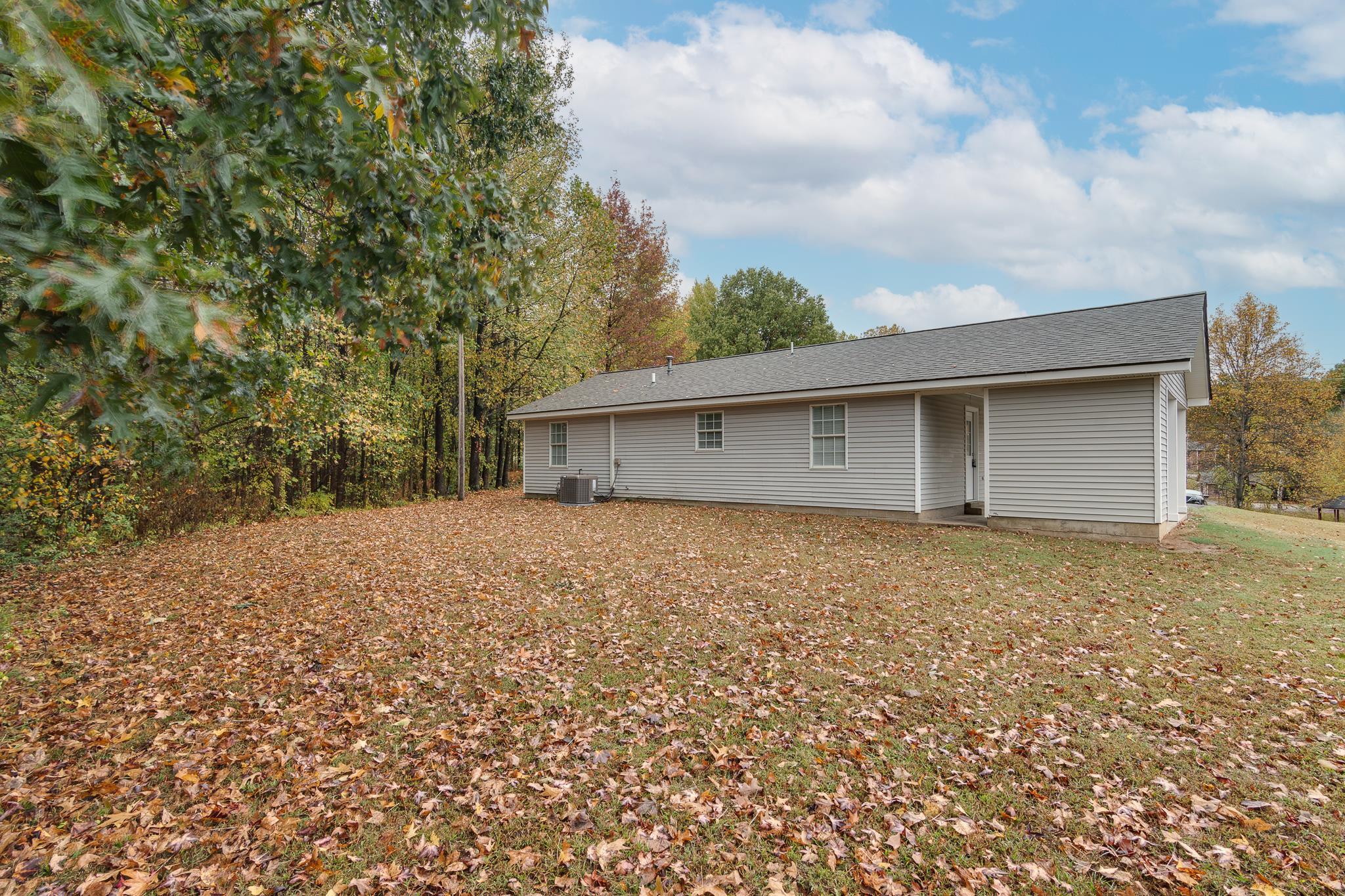 282 Volz Road Ripley, TN 38063 - Photo 18 of 25 a backyard of a house with large trees