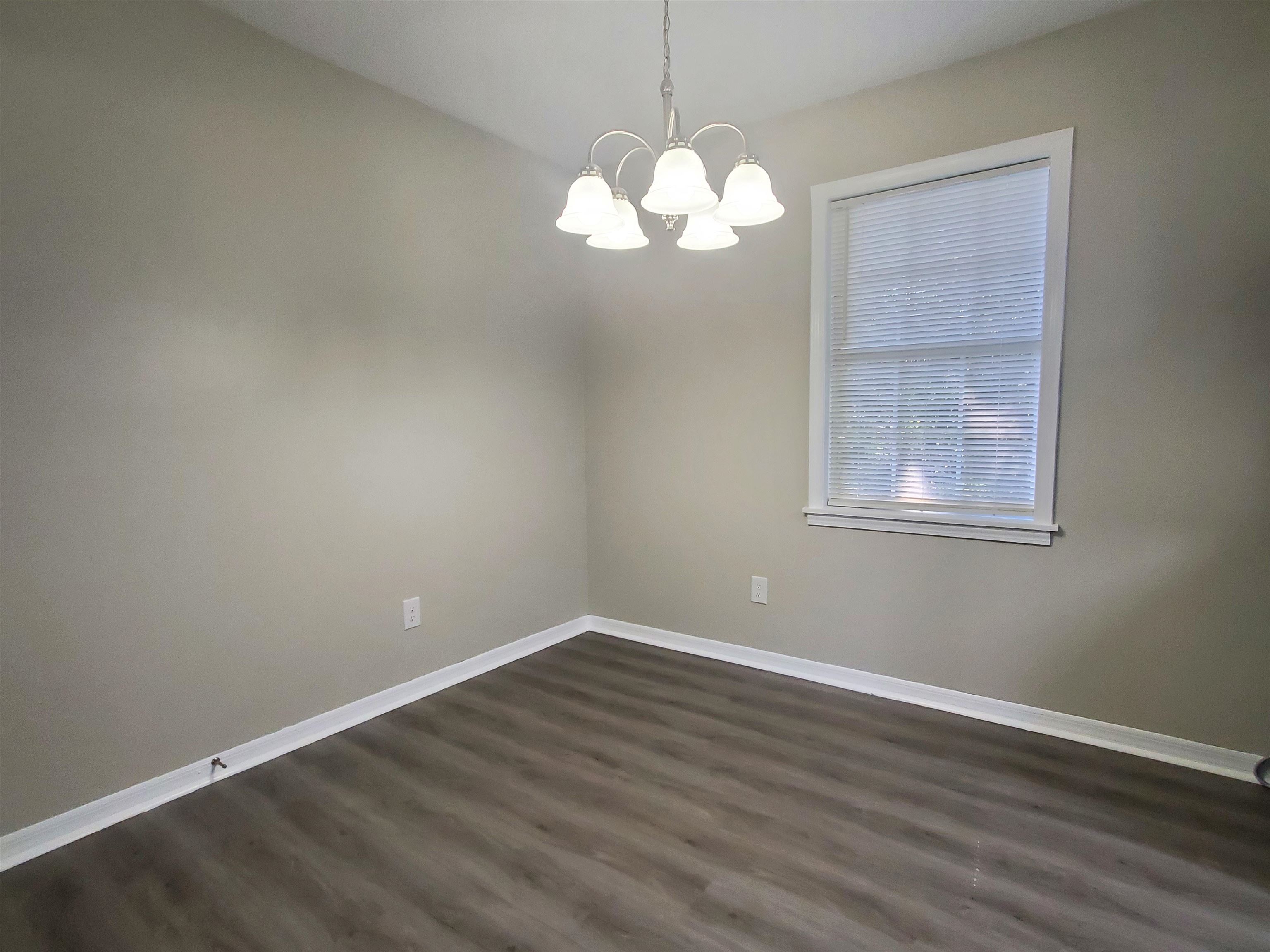 282 Volz Road Ripley, TN 38063 - Photo 3 of 25 an empty room with wooden floor and windows