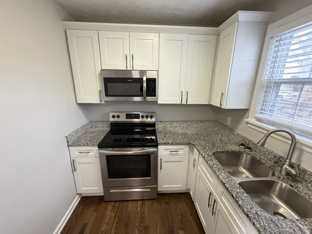 a kitchen with white cabinets sink and refrigerator